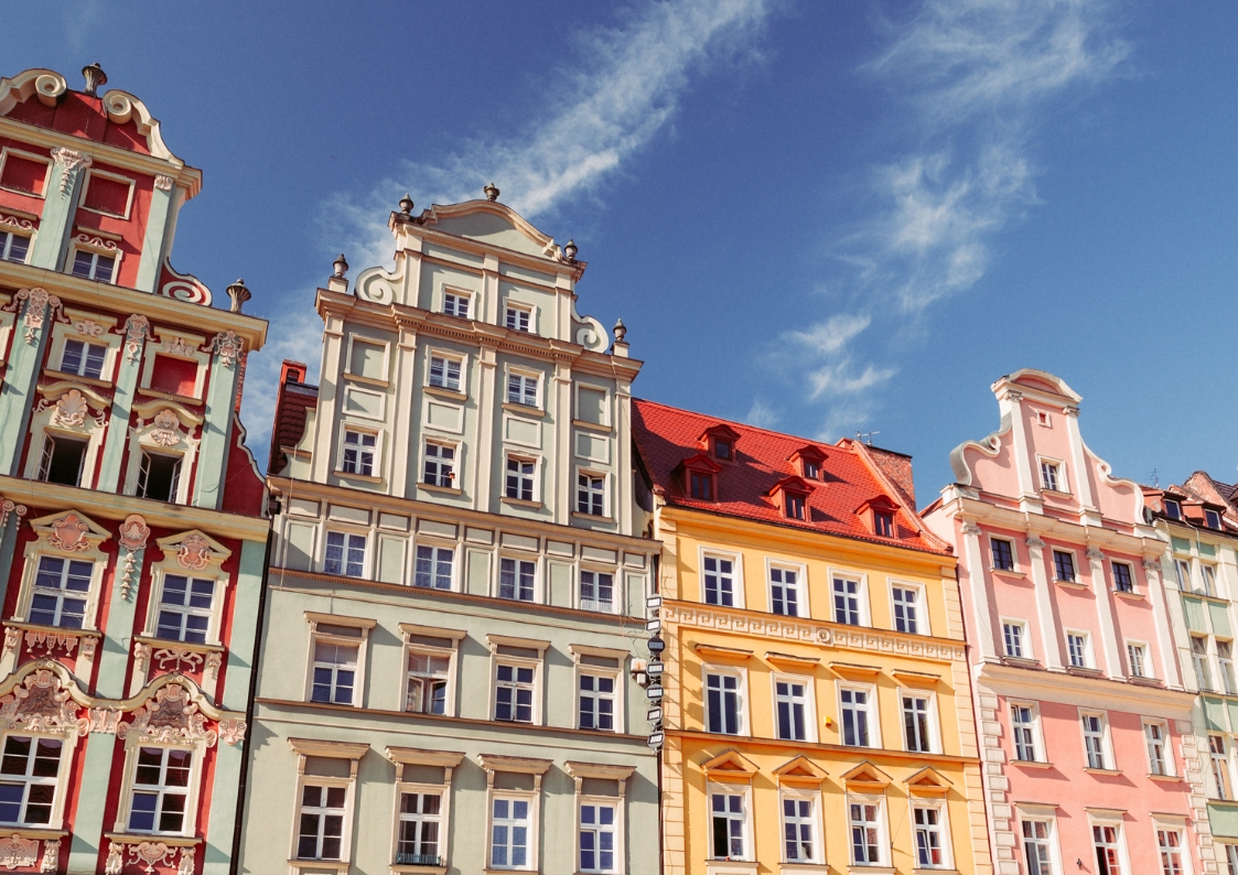 Wrocławskie kamienice na tle błękitnego nieba. Kolorowe elewacje ładnie wyglądają w słońcu.